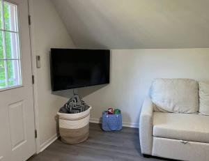 a living room with a couch and a flat screen tv at The Loft at Little Bear in Frankfort