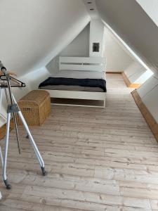 - une chambre mansardée avec un lit et un tripod dans l'établissement Bezauberndes Häuschen auf historischer Hofstelle, 