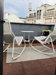 Duas cadeiras e uma mesa numa varanda em Nana Macs em Praga