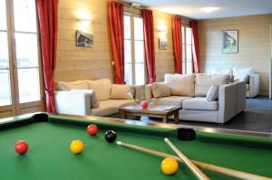 - un salon avec un billard et un canapé dans l'établissement Lagrange Vacances Les Arolles, à Saint-Gervais-les-Bains