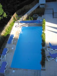 an overhead view of a large swimming pool with blue chairs at Lagrange Vacances Les Arolles in Saint-Gervais-les-Bains