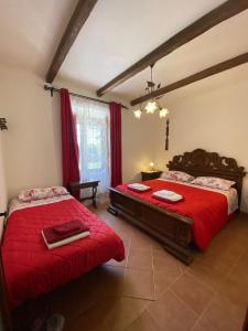 una camera con due letti con lenzuola rosse di Il CASALE NELLA TUSCIA. BIOFARM. Casa nel Giardino a Viterbo