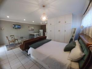 a bedroom with a large bed and a dining room at Lydiana Guesthouse in Pretoria