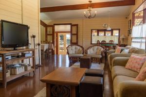 a living room with couches and a flat screen tv at Casa com lareira e lazer, em Campos do Jordao SP in Campos do Jordão