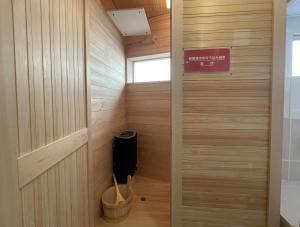 a sauna with wood paneling and a sign on the wall at Kohaku AMBER Kamakura Zaimokuza in Kamakura