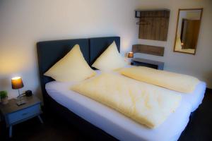 a bed with white sheets and pillows in a room at Breer S Hotel in Schwerte