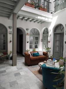 La Gitanilla Alojamiento & Encanto Jerez في خيريز دي لا فرونتيرا: غرفة معيشة مع أريكة وطاولة