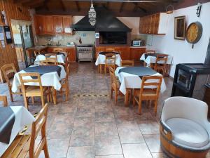 un restaurante con mesas y sillas y una cocina en Hostal Y Cabañas Don Juan, en Villarrica