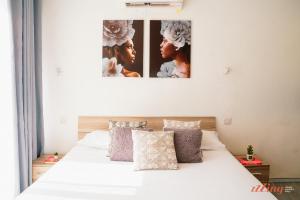 una camera con un letto bianco con due immagini sul muro di Country views by the sea. Holiday time in Gozo. a Żebbuġ