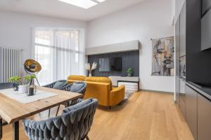uma sala de estar com uma mesa e cadeiras amarelas em Luxurious penthouse with parking em Riga