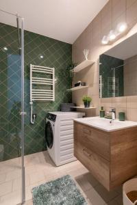 uma casa de banho com um chuveiro, um lavatório e uma máquina de lavar roupa em Luxurious penthouse with parking em Riga