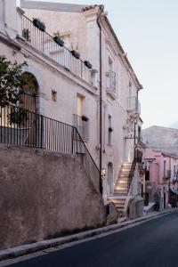 a building with stairs on the side of a street at Officine degli Aromi in Ragusa