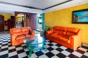 a living room with two leather couches and a glass table at OYO Hotel San Martin in Veracruz