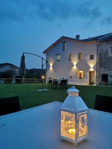a lantern sitting on a table in front of a house at Casa BORRIERO Farmhouse Charme B&B in Sospirolo