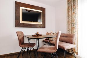 a dining room table with chairs and a mirror at Hotel Garni Tannenhof in Flachau
