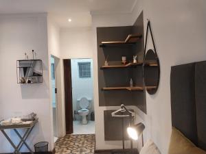 a room with a bathroom with a toilet and shelves at Lydiana Guesthouse in Pretoria