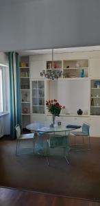 安科納的住宿－UrbinHouse1，一间设有玻璃桌和椅子的用餐室