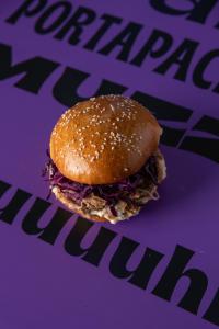 a pulled pork sandwich sitting on a purple paper at B&B Loricaly in Lorica