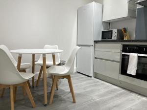 a kitchen with a table and chairs in a kitchen at Watford Central Apartments - Modern, spacious and bright 1 bed apartments in Watford