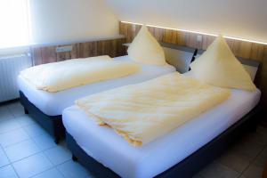 2 camas con sábanas blancas y almohadas en una habitación en Breer S Hotel en Schwerte
