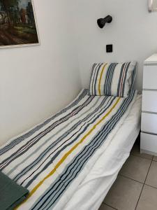 1 cama con almohadas a rayas en el dormitorio en SunShine Apartman, en Orfű