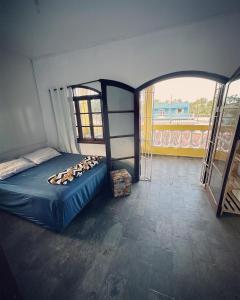 Cet appartement comprend une chambre dotée d'un lit et d'un balcon. dans l'établissement Pousada Ocean - Beira Mar, à Bertioga