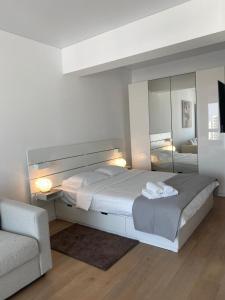 a bedroom with a large bed and a mirror at Queen's Studio Deluxe Mamaia Nord in Mamaia Nord