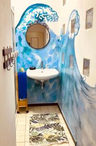 a bathroom with a painting of a wave on the wall at Night Galleria Holiday Villa Liguria 