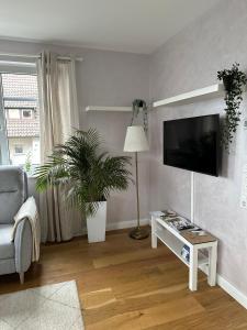 a living room with a flat screen tv and a chair at OD Ferienwohnung in Bad Salzuflen