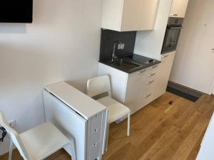 a white kitchen with a sink and a table and chairs at Serviced Appartements im Zentrum Rohrbach #Komplett ausgestattet in Rohrbach-Berg