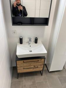 a person taking a picture of a sink in a bathroom at Serviced Appartements im Zentrum Rohrbach #Komplett ausgestattet in Rohrbach-Berg