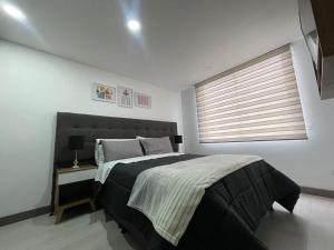 um quarto com uma cama grande e uma janela em Magnifico y confortable apartamento amoblado # 303 em Bogotá