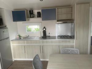 - une cuisine avec un évier et un comptoir dans l'établissement Mobil-home Confort TV CLIM Narbonne-Plage, à Narbonne-Plage