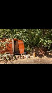little vintage caravan with cosy log burner في كانتربيري: جلسة مقطورة برتقالية فوق الميدان