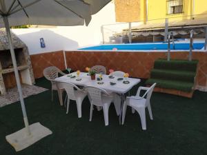 a white table with white chairs and an umbrella at Carmen House 