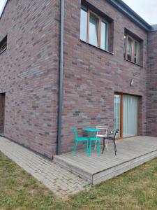 a patio with a table and chairs on a brick building at Apartamentai in Garliava