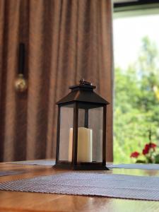 una vela en una linterna sentada sobre una mesa en Cabana Dintre Fagi en Poiana Mărului