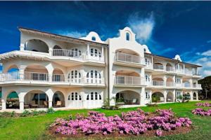 a large white building with pink flowers in front of it at Royal Westmoreland - Royal Apartment 214 by Island Villas in Saint James