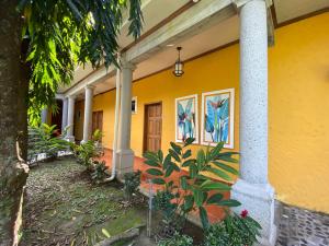 una casa amarilla con pinturas al costado. en Paraiso Rainforest and Beach Hotel, en Omoa