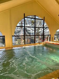 a swimming pool with a large window in a building at Chocoland Hotel Gramado soft opening in Gramado