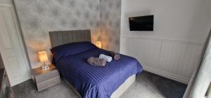 a bedroom with a bed with two stuffed animals on it at Cosy, spacious and comfortable family home. in Kirkburton