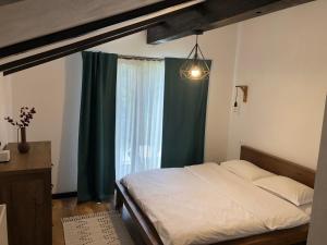 1 dormitorio con cama y ventana grande en Cabana Dintre Fagi en Poiana Mărului