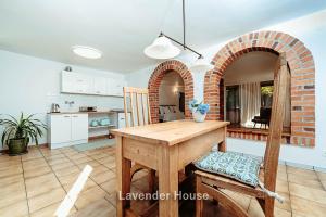 a kitchen and dining room with a wooden table at Lavender House in Osieki +92 photos
