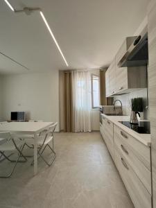 uma cozinha com uma mesa branca e uma mesa e uma mesa e um ecrã em Villa Family House , Senigallia , Trecastelli (AN) em Molino di Ripe