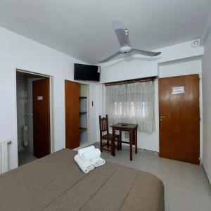 Schlafzimmer mit einem Bett, einem Deckenventilator und einem Tisch in der Unterkunft Posada del Angel in Neuquén