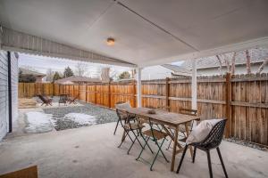 eine Terrasse mit einem Tisch, Stühlen und einem Zaun in der Unterkunft Ranch Style Home Playretreat 6 Mi Denver in Wheat Ridge