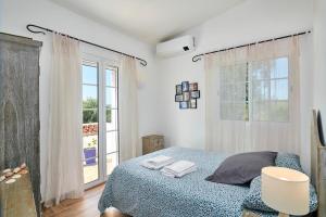 a bedroom with a bed and a large window at Laranjeira by Vintage Travel in Tavira +22 photos