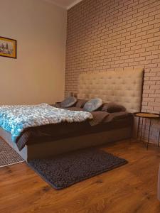 een slaapkamer met een bed en een bakstenen muur bij Apart23 in Lviv