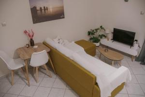 - un salon avec un canapé et une table dans l'établissement Just A Stay apartement, à Chios