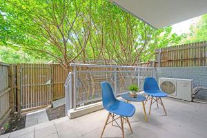 a patio with two blue chairs and a table at Castle HIll Sweet Modern 3BR Apt with 2 Parking in Castle Hill